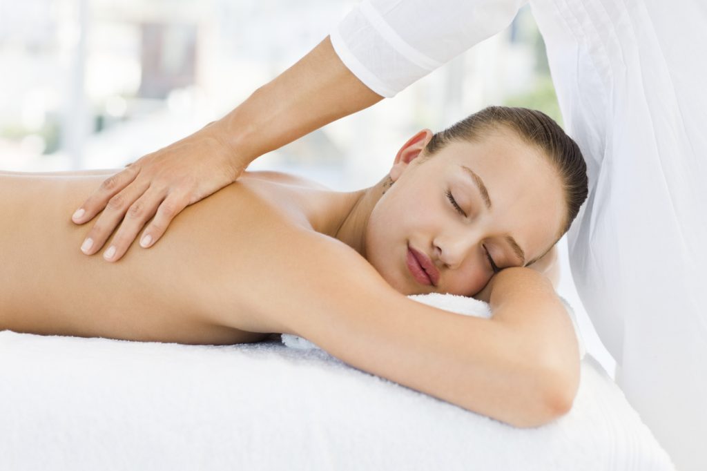 Relaxed pretty young woman receiving back massage